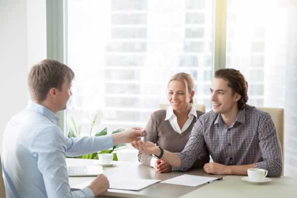 Couple at table talking with realtor