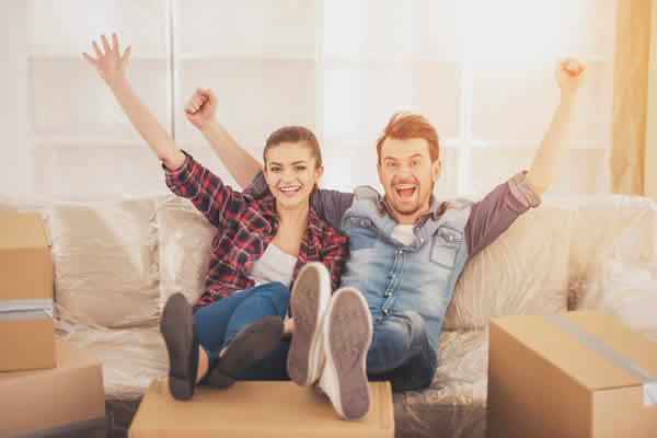 Couple on couch rejoicing
