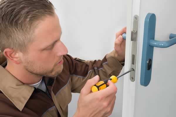 Man using screwdriver to change door lock