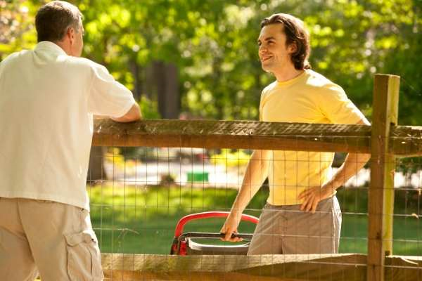 Two people talking over fence