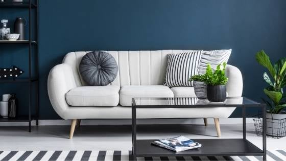 White sofa in front of dark blue wall