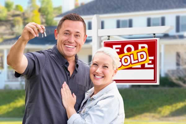 Couple hugging in front of home