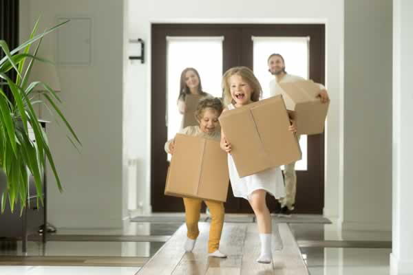Kids carrying boxes entering home