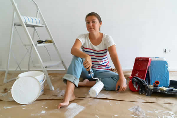 Woman sitting on floor with paint supplies