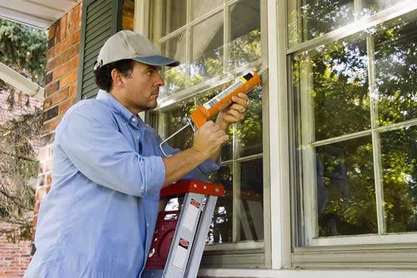 Repair person caulking windows