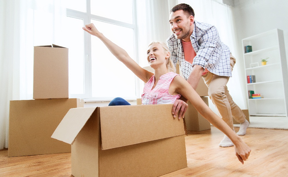Man pushing happy woman in packing box