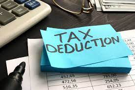 Note pad on desk says Tax Deduction