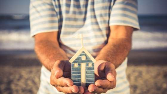 Pair of hands holding mock up of a home