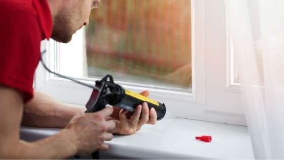 Man caulking window