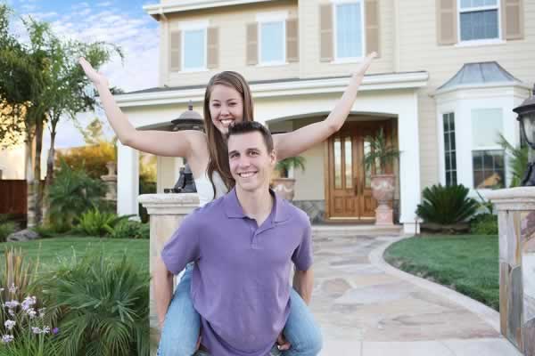 Picture of young couple in front of house