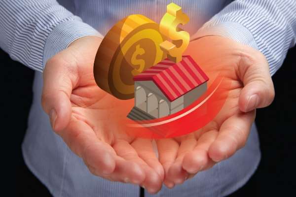 Two hands holding coins and toy house